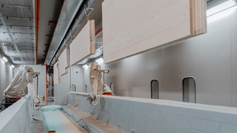 In het oppervlaktecentrum van de HASSLACHER-groep in Stall (Mölltal) verfijnen twee volautomatische lakrobots elementen uit kruislagenhout met hoogwaardige coatings van ADLER. | © ADLER
